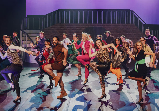 Full cast dance number in vibrant 80s-inspired costumes on a two-level courtyard set, Legally Blonde musical, National Theatre St Kilda, July 2025.